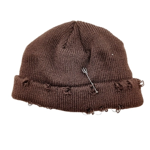 Détail du bonnet marron foncé avec épingle de sûreté et trois anneaux métalliques style usé