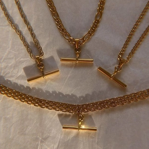 Four 18K gold plated stainless steel necklaces with T-bar pendants and varied chain designs