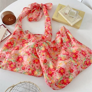 Floral tote bag detail featuring large bow shoulder strap and colorful summer flower print