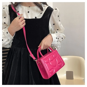 Détail du sac en cuir PU rose avec motifs de cœurs gravés et bandoulière réglable