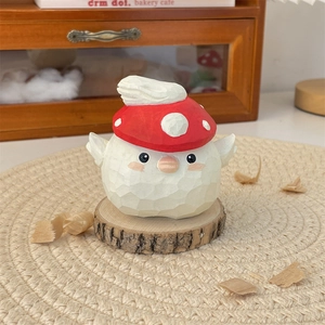 Close-up of hand-carved wooden chick ornament with a red mushroom hat on wood base