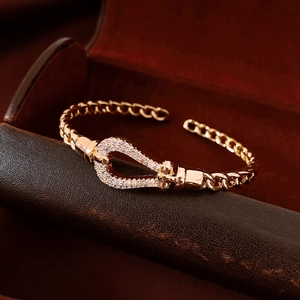 Detailed macro view of an 18K gold-plated teardrop shackle bracelet with pave-set zircons