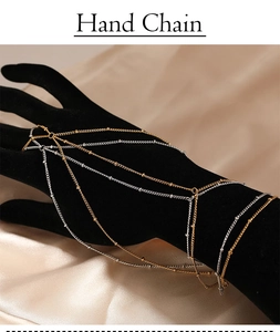 Detailed close-up of multilayer gold and silver hand chain on a black velvet display