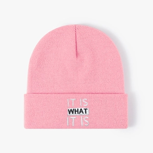 Pink knitted beanie featuring IT IS WHAT IT IS embroidery for winter warmth and style