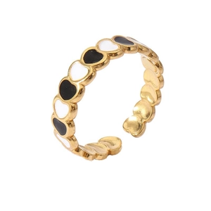 Detailed close-up of adjustable 18k gold plated ring with black and white enamel hearts