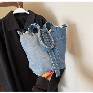 Detail view of denim patchwork handbag with dual-tone blue fabric and adjustable strap