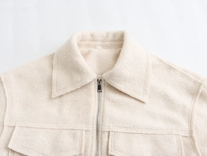 Détail de la veste en laine beige texturée avec fermeture éclair et col classique