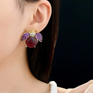 Macro view of vintage beetle stud earring with purple enamel and crystal embellishments