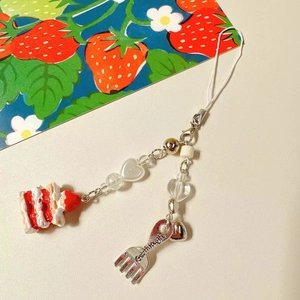 Cute strawberry cake handmade beaded charm with metal fork and heart beads on light background