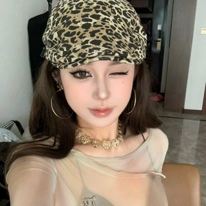 Detailed close-up of leopard print headband and large gold hoop earrings on model