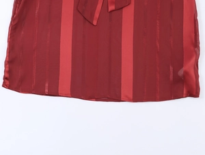 Close-up of wine red striped top featuring sheer chiffon texture and flowy hemline detail
