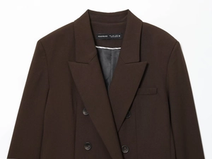 Detailed view of the dark brown double-breasted blazer with twill texture and logo label