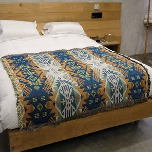 Close-up of bohemian jacquard knit blanket with geometric patterns and fringe tassels