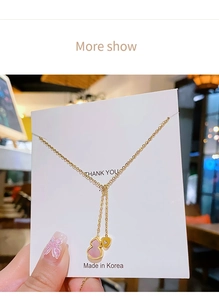 Detail view of 18k gold plated stainless steel necklace with pink gourd and heart pendant