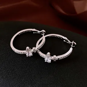 Silver plated hoop earrings with shimmering crystals and a drop shaped zircon charm