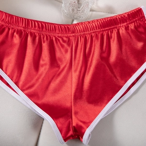 Dettaglio dei pantaloncini sportivi in raso rosso con trama liscia e vita elastica bianca