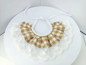 Detail of khaki houndstooth pet bib with wide white lace trim and adjustable drawstring