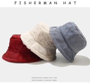 Close-up of plush fisherman hats in red, cream white, and blue-grey showing soft texture