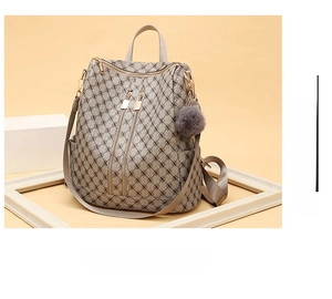 Detail of taupe monogram backpack with dual metal zippers and grey pompom keychain