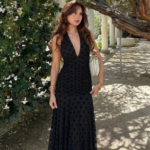 Detail of black polka dot backless maxi dress with halter V-neck and ruched waist