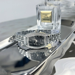 Macro view of tonneau emerald quartz watch with silver metal strap and rhinestone bezel