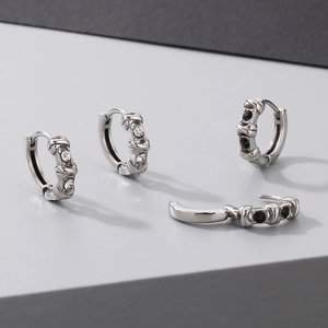 Detailed view of titanium steel cross earrings with black and white zircon stone inlay
