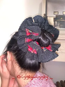 Detailed view of large black pleated scrunchie with red and green plaid patterns