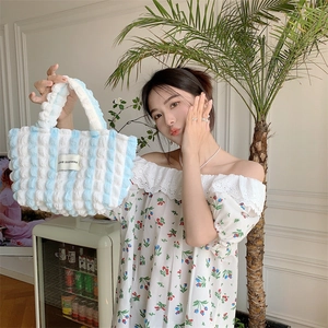Close-up of puffy bubble fabric handbag with blue vertical stripes and LOVE SOZAKKA label