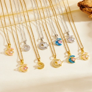 Detailed view of gold and silver celestial necklaces on soft beige silk with dried flowers
