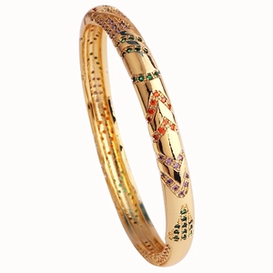 Detail of luxury gold-plated bangle with multi-color V-shaped zircon inlay on white base