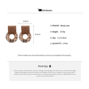 Detail view of ethnic resin earrings with wood squares and calligraphy pattern