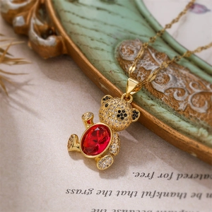 Macro shot of gold bear pendant with red gemstone and micro-pave zircon details