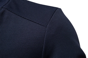 Close-up of navy waffle knit fabric texture and shoulder seam on men's jacket