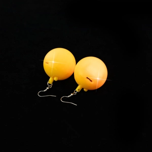 Close-up of glowing yellow disco ball earrings with metal hooks and light-up effect