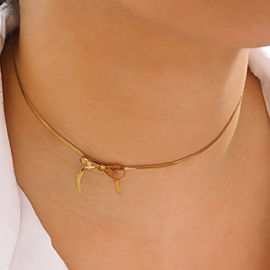 Golden bow snake chain necklace for women showing polished metallic luster on skin
