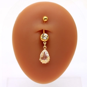 Dettaglio del piercing all'ombelico dorato con zirconi trasparenti e pendente a goccia