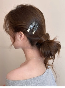 Macro shot of grey marble hair clips with colorful rhinestones on a female model