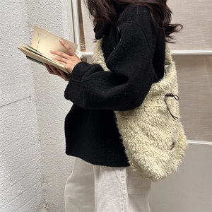 Detail of soft cream lamb wool tote bag with brown leather drawstring and metal eyelets