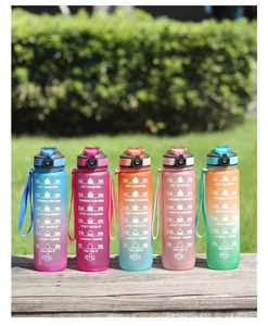 Detail view of five gradient 1000ml sports water bottles with time markers on a bench