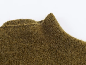 Close-up of premium knit texture showing soft plush mohair fibers on asymmetrical sweater