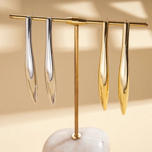 Boucles d'oreilles minimalistes plaquées or 18 carats et argent sur un présentoir en T