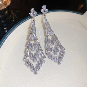 Close-up of elegant silver tassel earrings with sparkling zircon crystals in a jewelry box