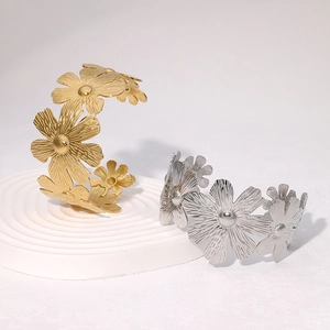 Floral stainless steel open bangles in gold and silver finish on white stand