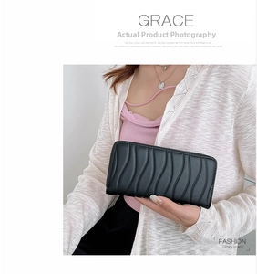 Detailed view of women's black long wallet featuring a 3D wave textured surface with zipper