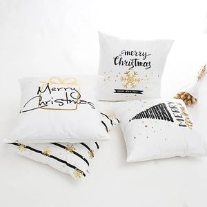 Set of four white Christmas pillow covers with gold foil snowflakes and festive lettering
