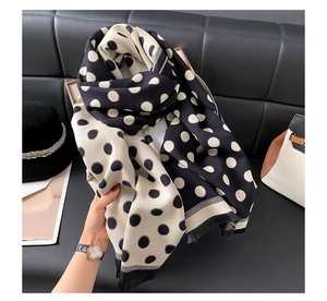 Detailed view of the soft thick black and white polka dot scarf with fringe tassels