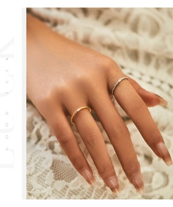 Detail of minimalist gold and silver rings with textured bands and rectangular zirconia