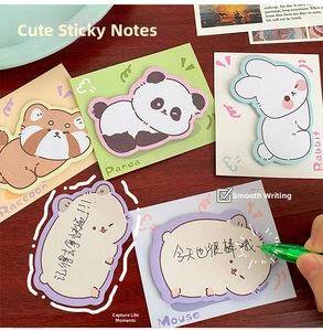 Close-up of cute cartoon animal sticky notes set with writing action on wood background