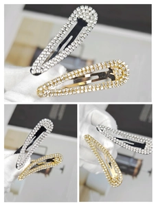 Close-up of gold and silver metallic rhinestone snap hair clips with sparkling finish