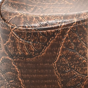 Close-up of vintage brown cowboy hat leather texture with detailed leaf vein embossing